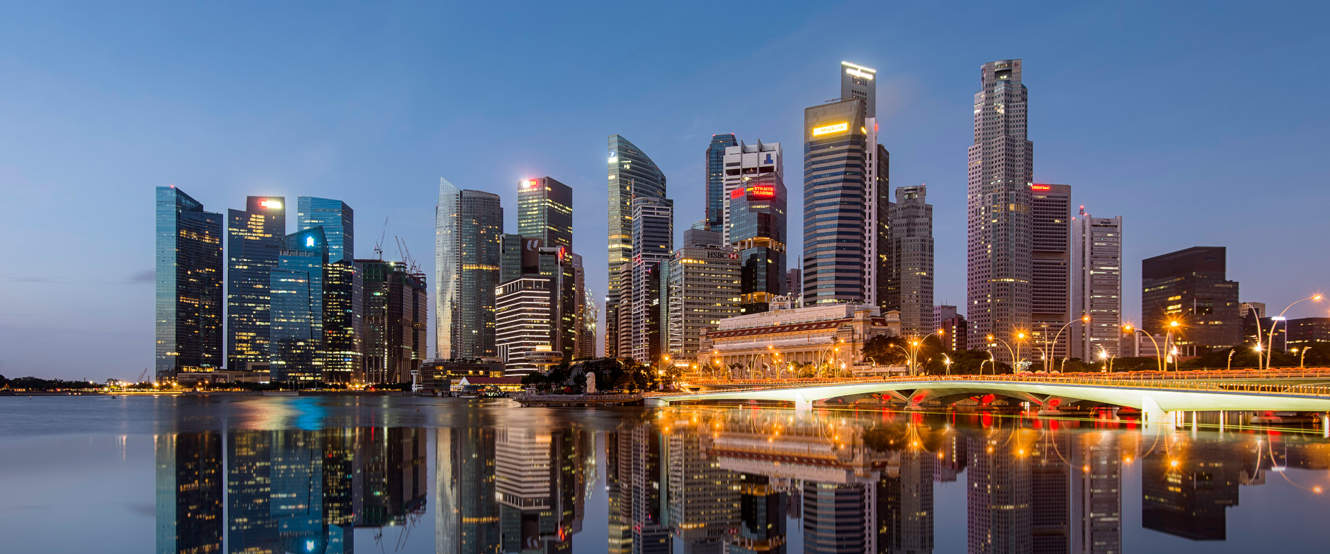 The Singapore city skyline at dusk, reflected in the still water in front
